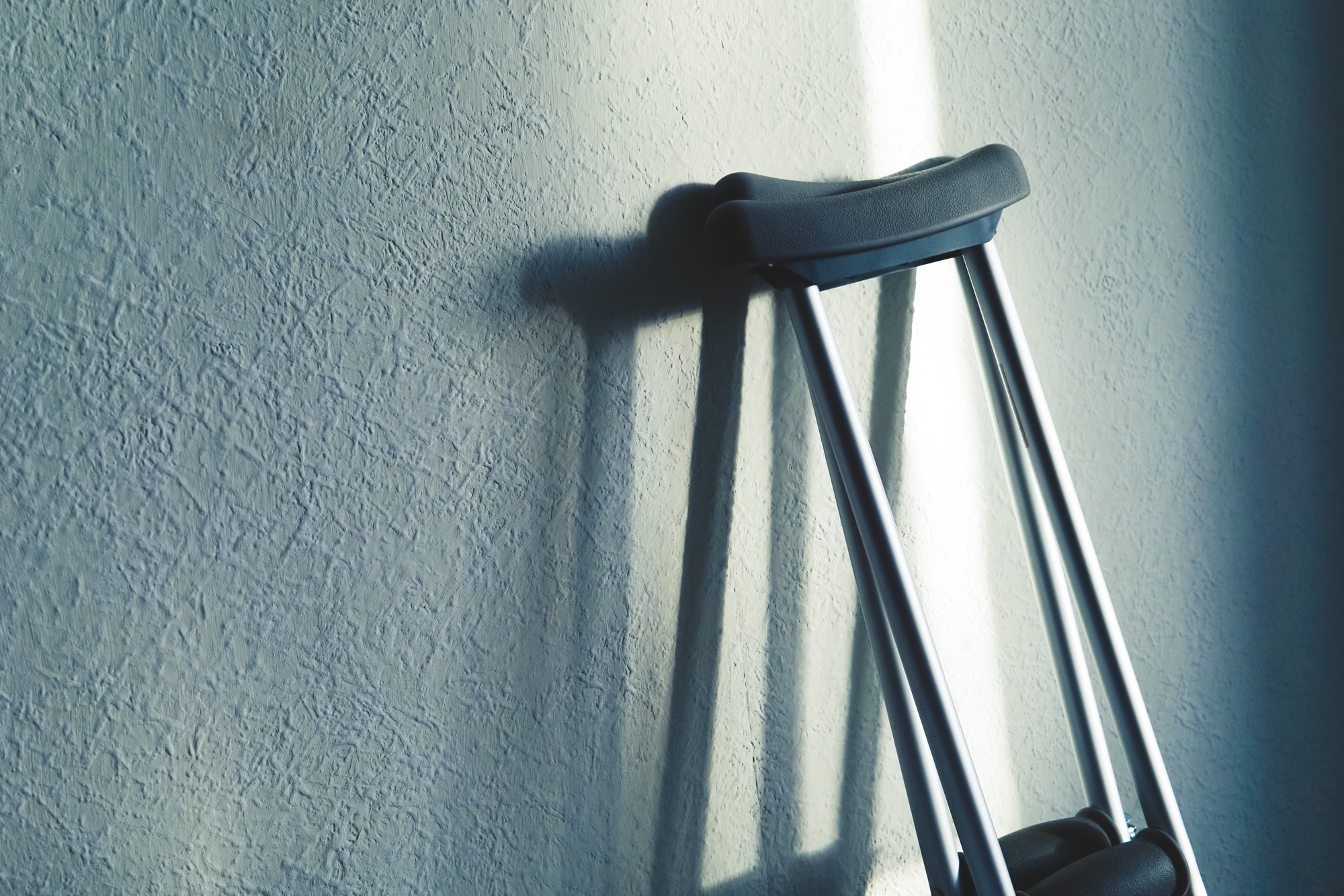 Close up image of crutches are standing against the wall. Place for text.